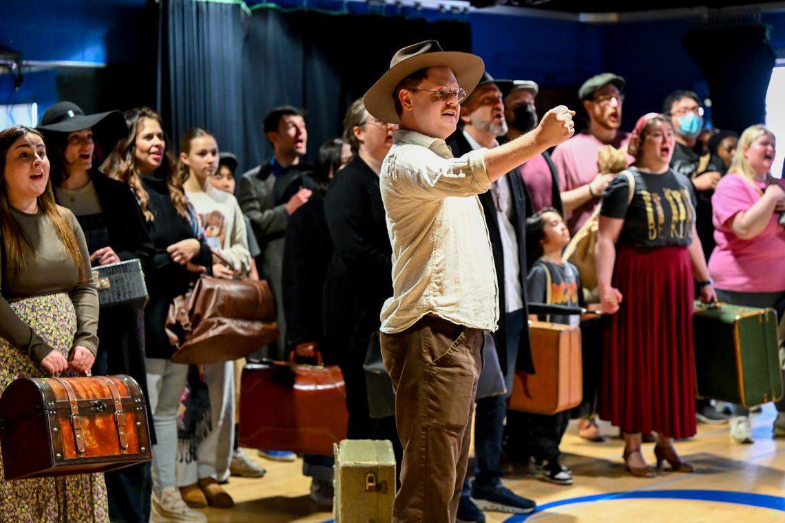 A crowd of singers portray a variety of people from numerous countries on New York's Ellis Island hoping to immigrate to the United States in the opening scene of "A Nation of Others." The University of Kentucky Opera Theatre presents the world premiere of "A Nation of Others," an opera by Paul Moravec with a libretto by Mark Campbell. This photo was taken at a rehearsal February 28, 2026 in the Schmidt Vocal Arts Center on the University of Kentucky Campus in Lexington, Kentucky.