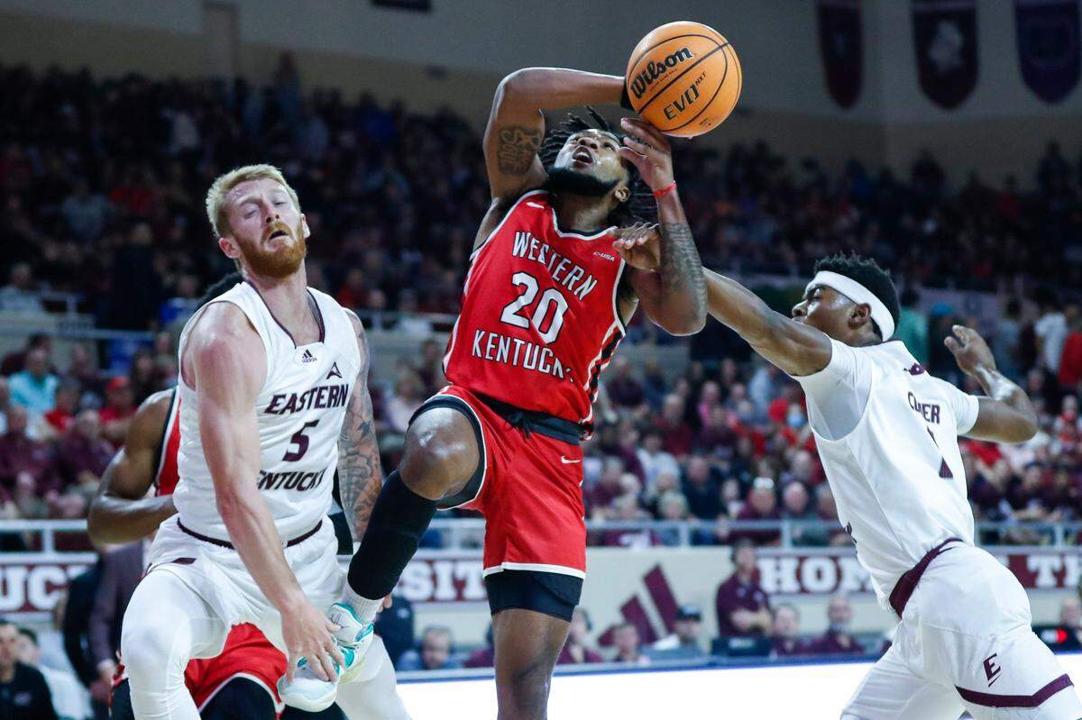Western Kentucky’s Dayvion McKnight (20) drives against Eastern Kentucky’s Cooper Robb (5) on Thursday night.