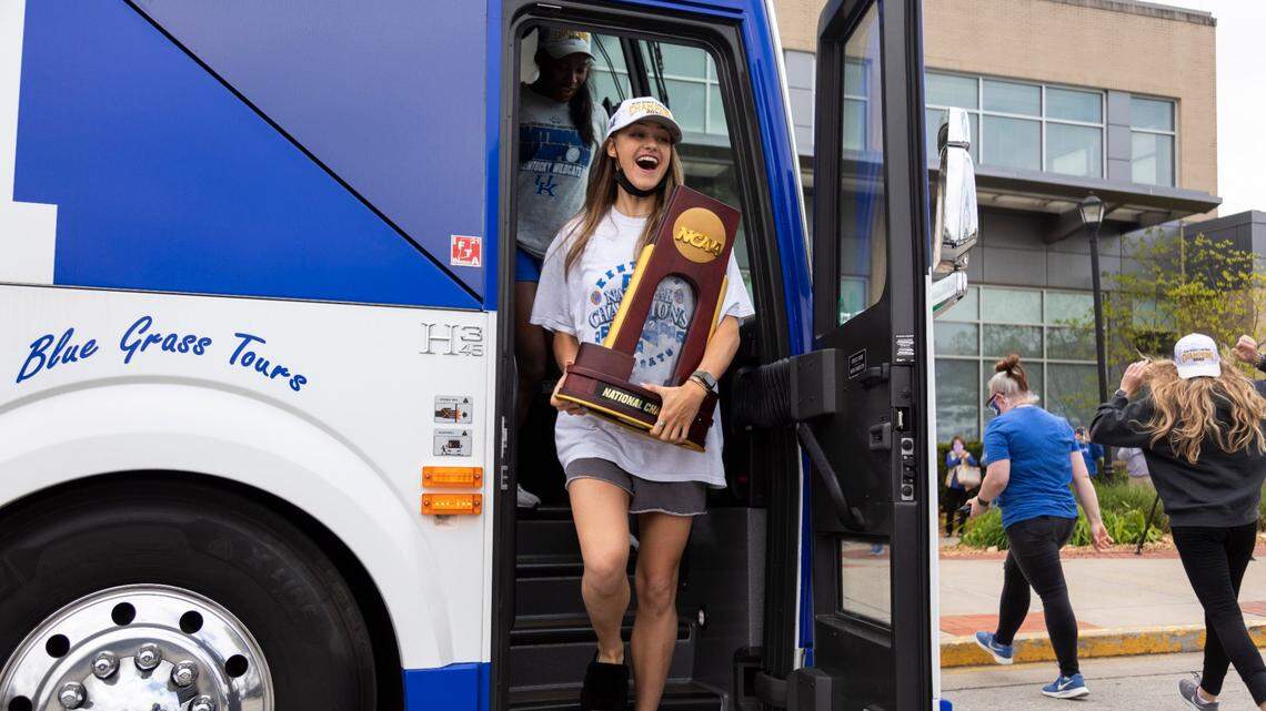 Kentucky senior Madison Lilley holds the NCAA championship trophy while exiting the bus returning from Omaha after the team won the program’s first NCAA title.