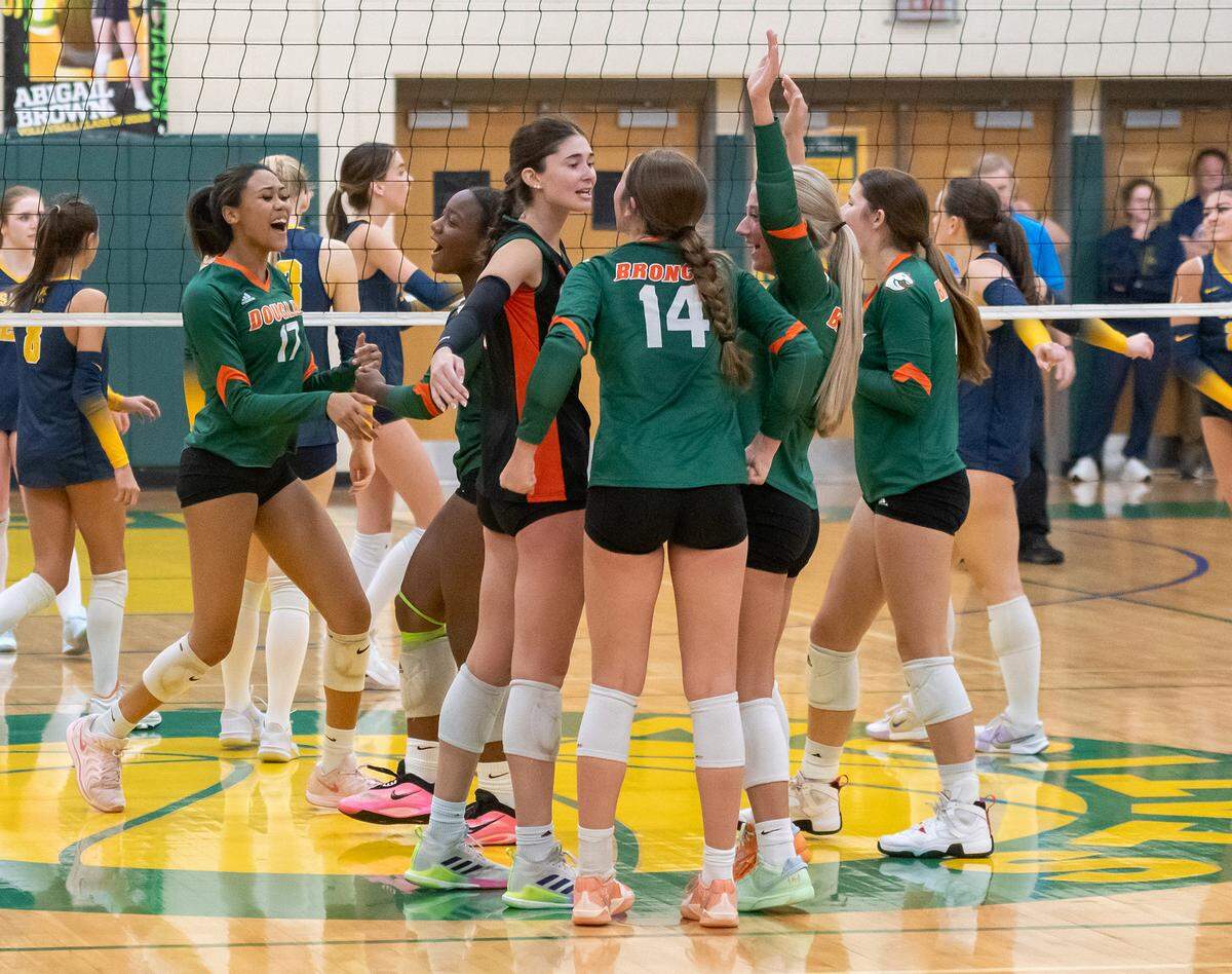 Frederick Douglass players celebrate after the Broncos’ 3-1 win in the 42nd District girls volleyball tournament championship game at Bryan Station High School on Thursday.