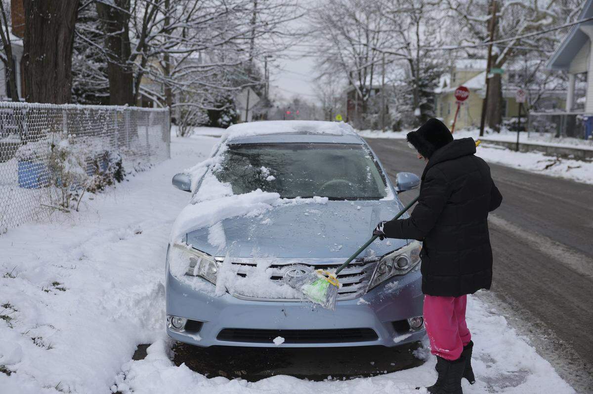 Dora Hisel clears snow from her car in Lexington, Ky., Friday, Dec. 12, 2025.