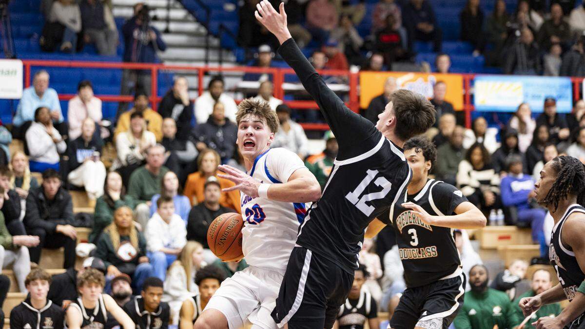 Madison Central’s Jake Feldhaus (20) went up for a shot against Frederick Douglass center Nate Coen during the Indians’ 69-66 win at Madison Central High School in Richmond. on Jan. 23.