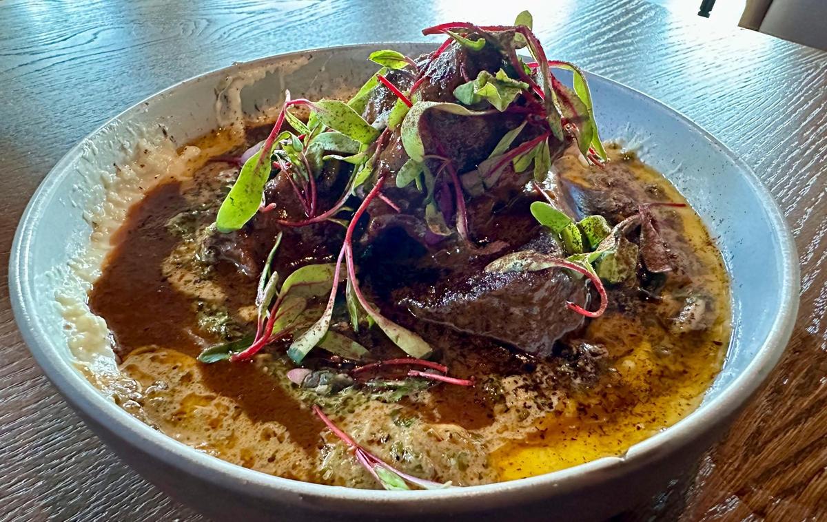 Corn husk braised tri tip appetizer at Granddam, located in the Manchester Hotel in Lexington’s Distillery District, July 14, 2024. The Bourbon braised Black Hawk Farms tri tip was made with Kenny’s Farmhouse 12-year white cheddar, Weisenberger Mill grits, mustard chimichurri and tableside smoked.