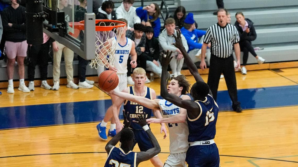 Lexington Catholic’s Max Meagher (24) shot around Danville Christian’s Leek Ateny (15) during the Knight’s 55-54 win over the Warriors at Lexington Catholic High School on Feb. 18.