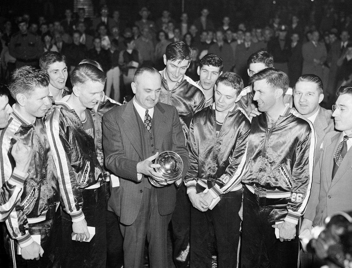 Coach Adolph Rupp and his Kentucky Wildcats admired the NCAA basketball title cup in 1949, which they won in Seattle by defeating Oklahoma A&M 46-36. Front row left to right: Jim Line, Walter Hirsch, Coach Rupp, Ralph Beard and Cliff Barker.