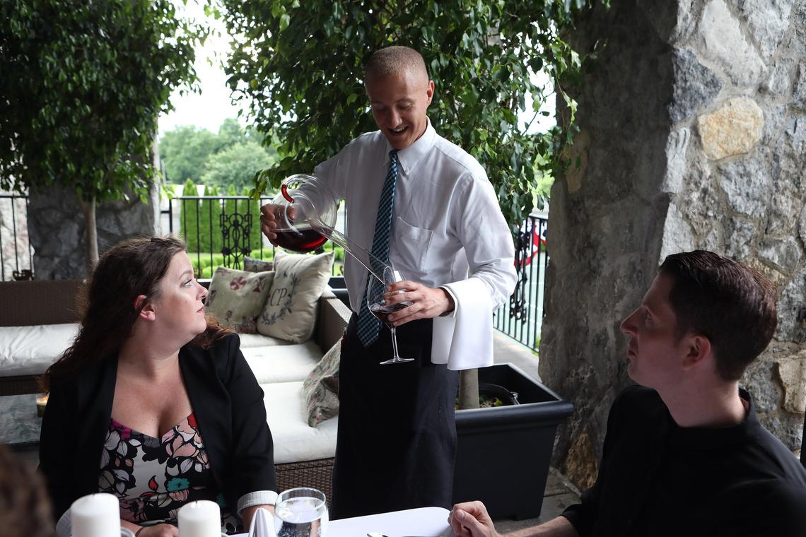 Kyle Powell serves wine using a chilled wine snake Tuesday at Castle Farm restaurant in The Kentucky Castle.
