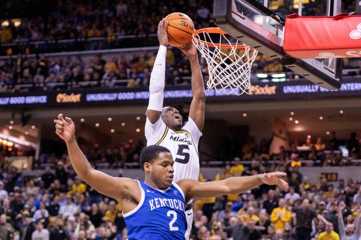 Missouri’s D’Moi Hodge, top, dunks the ball over Kentucky’s Sahvir Wheeler during the second half of an NCAA college basketball game Wednesday, Dec. 28, 2022, in Columbia, Mo. Missouri won 89-75.(AP Photo/L.G. Patterson)
