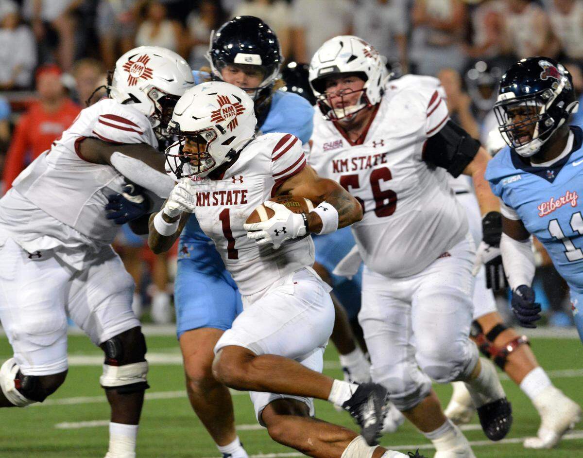 Seth McGowan takes the ball to the outside of the Liberty defense during the first half of Saturday night's game at Aggie Memorial.