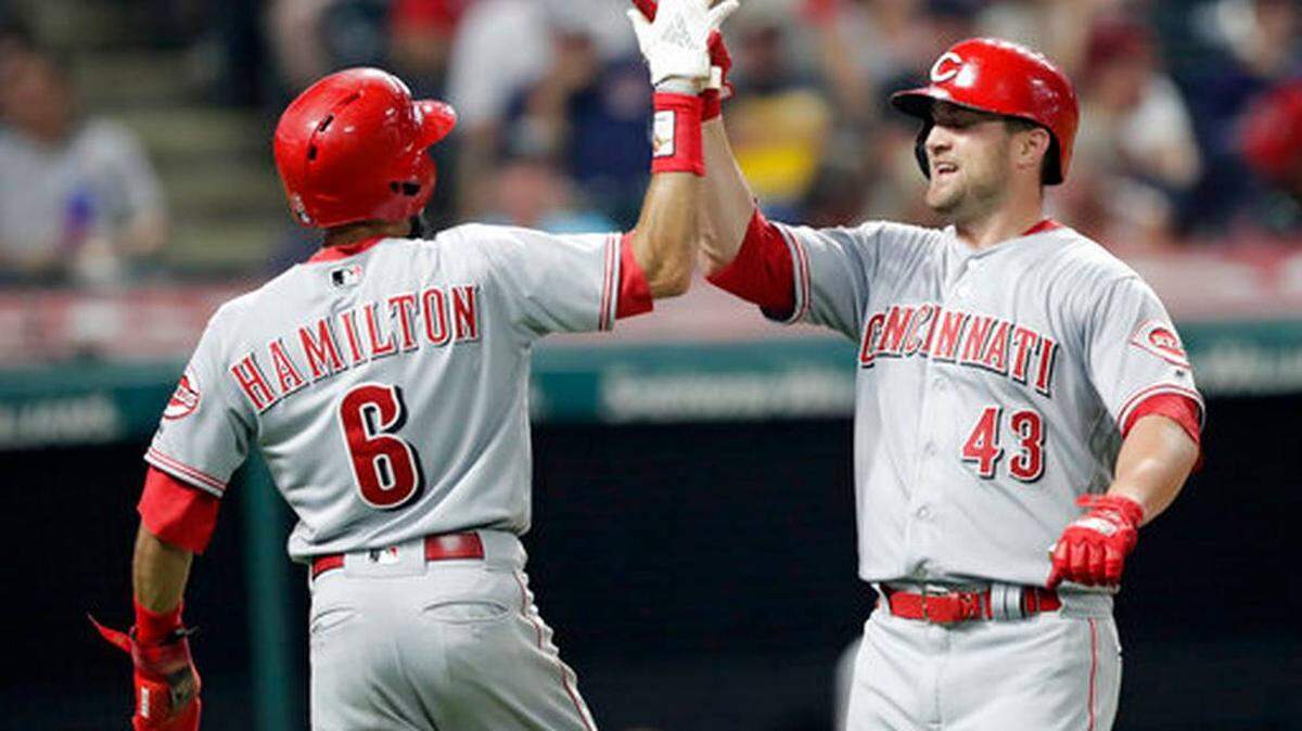Cincinnati Reds’ Scott Schebler, right, is congratulated by Billy Hamilton after Schebler hit a two-run home run off Cleveland Indians relief pitcher Josh Tomlin in the ninth inning of a baseball game, Monday, July 9, 2018, in Cleveland. Hamilton scored on the play.