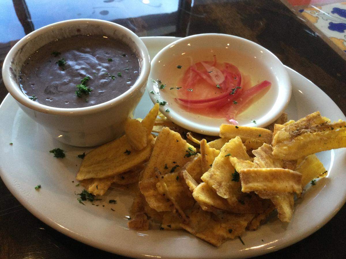 The criollo bean dip at Hola Havana comes with mojo sauce, which is olive oil with garlic, red onions and lime juice in oil. Dip the plantain chip in the bean dip and then in the mojo sauce for a delicious snack.
