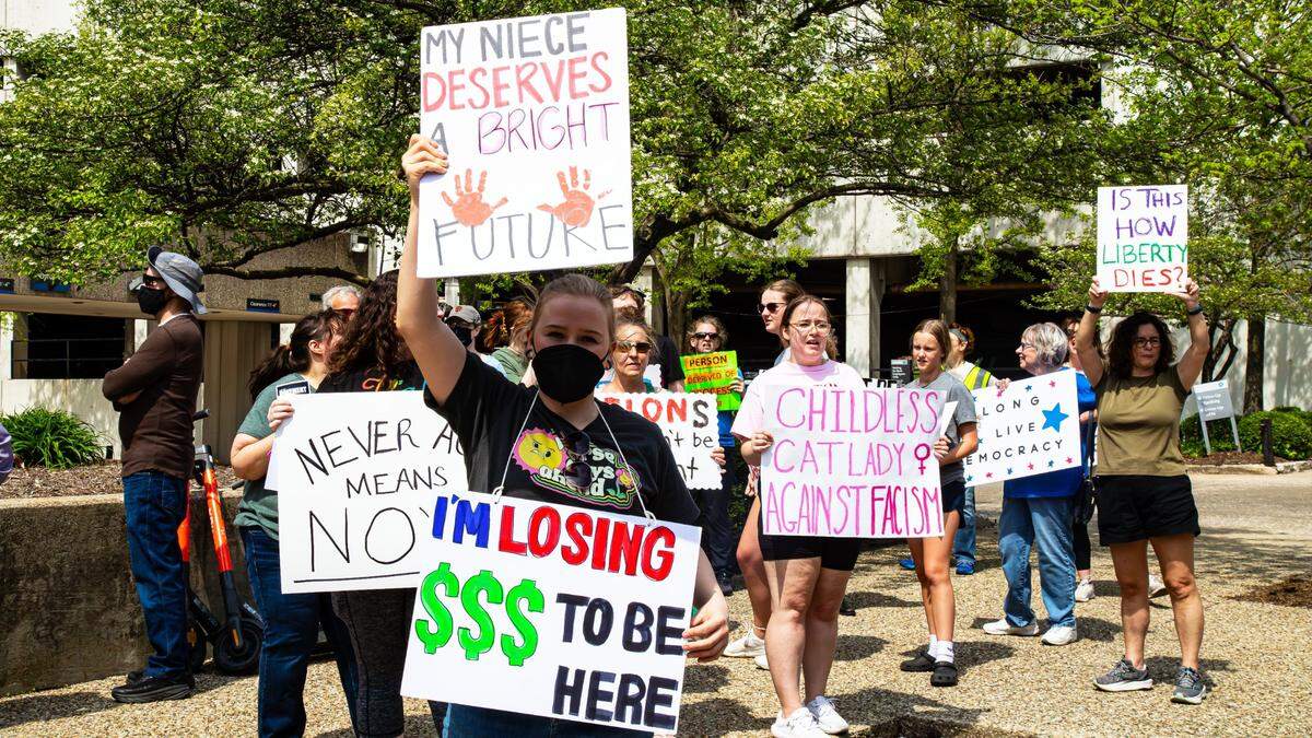 Women hold protest signs expressing concerns for the future of children, single women and American civil liberties during the “No Kings Then, No Kings Now” Peaceful March and Protest in front of the Robert F. Stephens Courthouse, downtown Lexington, Ky, on April 19, 2025.