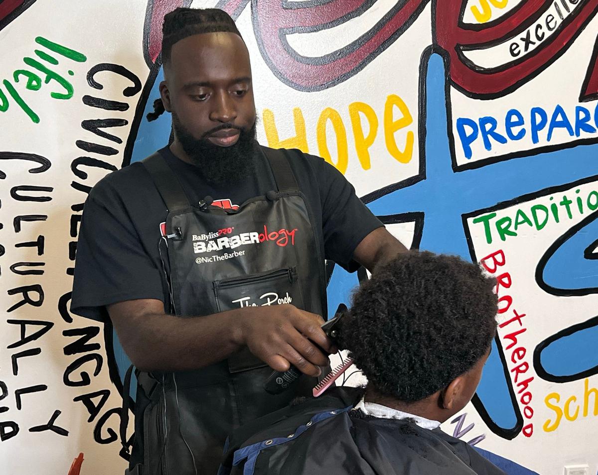 A Tates Creek Middle School student gets a professional haircut from local barber Nicolas Petit Frere during the official kicking off of a partnership program with the non-profit organization “Sharp Futures,” on September 16, 2024, in Lexington, Ky