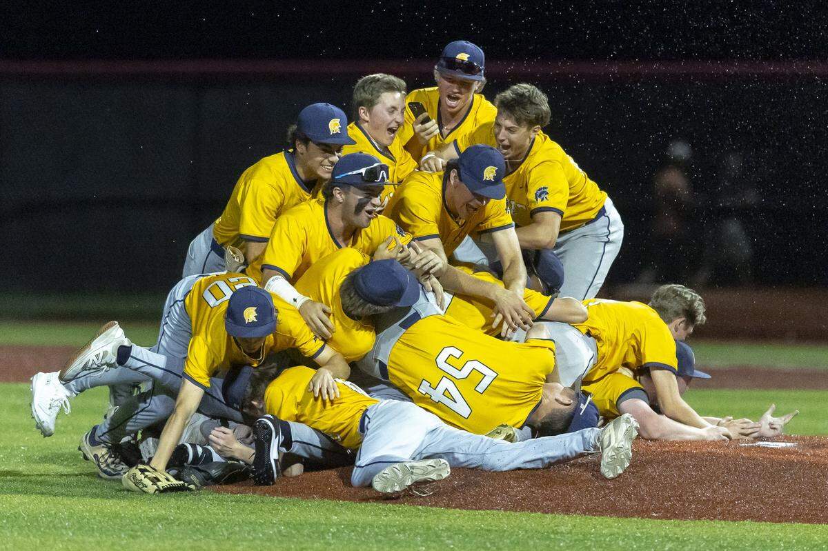 Sayre’s players storm the mound to celebrate winning the 11th Region Baseball Tournament championship game at George Rogers Clark High School in Winchester on Thursday.