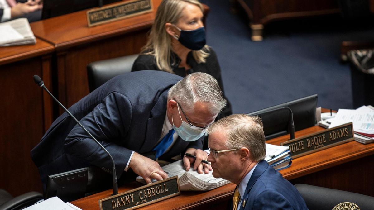 Kentucky Sen. Danny Carroll, left, R-Benton, speaks with Sen. Damon Thayer, R-Georgetown, on the Senate floor at the Kentucky state Capitol in Frankfort, Ky., on Tuesday, March 30, 2021, the final day of the 2021 legislative session.