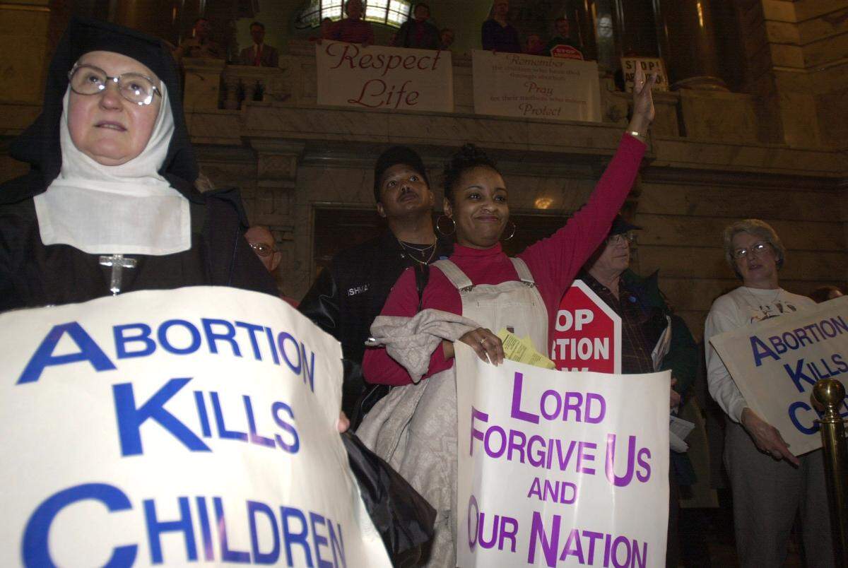 Karen Brooking of Louisville raises her hand in the air while listening to one of the many speakers during an anti-abortion rally in the rotunda of the Capitol in Frankfort, Ky., Jan. 30, 2002. Behind Brooking is her husband Robert and to the left is Sister Mary Gemma Younger of New Haven.