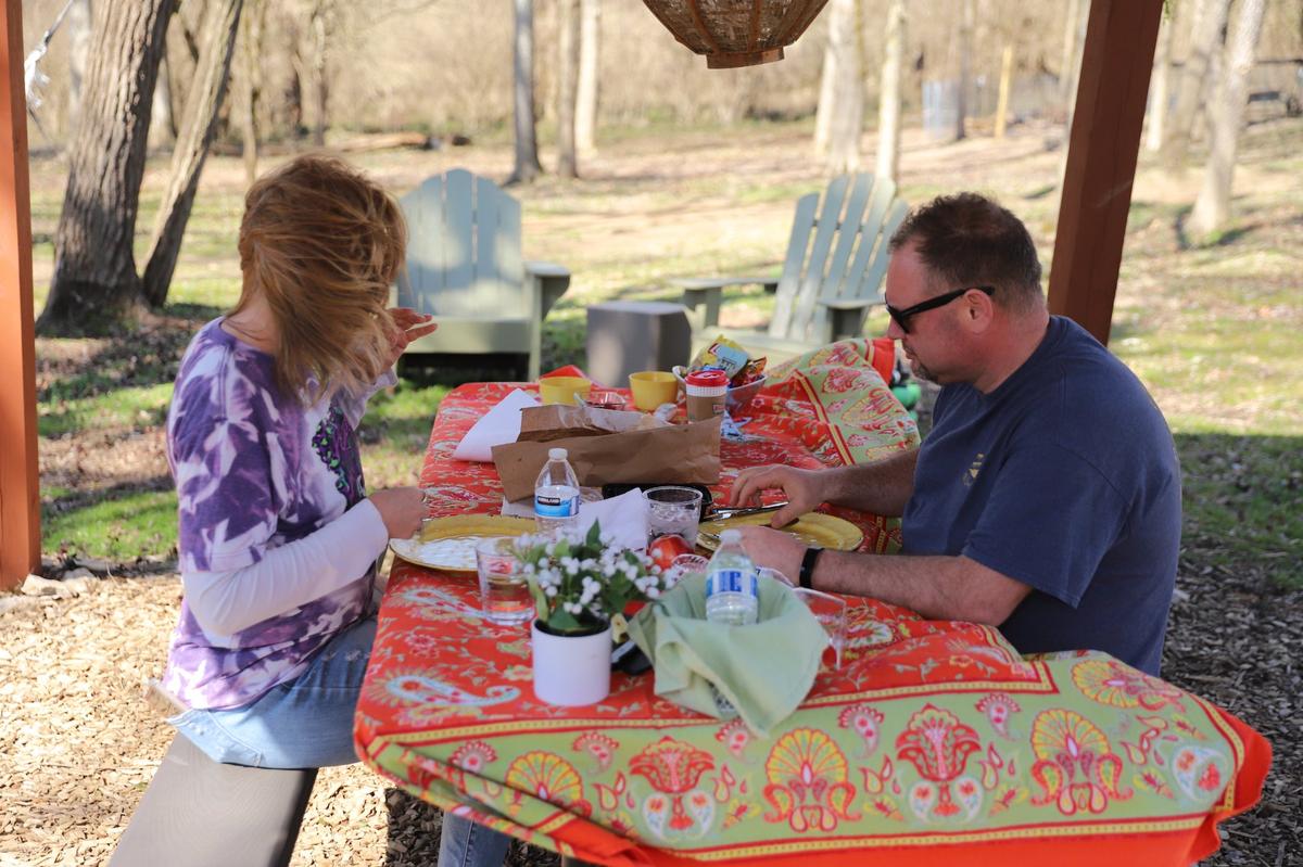 Visitors Angie Siemer and Jeff Marvin of Lancaster, Ohio, prepare for their picnic lunch at Picnic with Goats on a breezy Saturday afternoon in Lexington on March 5, 2022.
