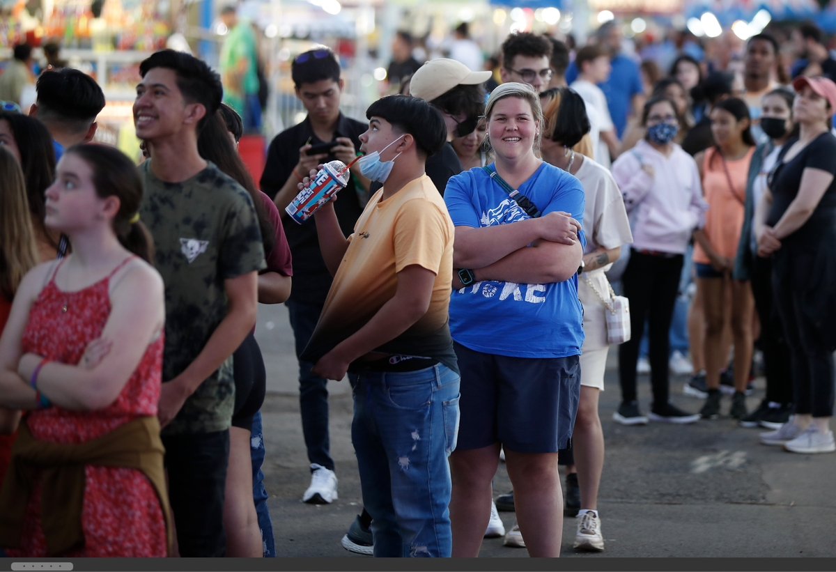 People wait in line for a ride at the Bluegrass Fair in Lexington. Though most fairgoers chose not to wear a mask, some still did, even though a majority of the city is vaccinated and the chance of transmission outdoors remains low.