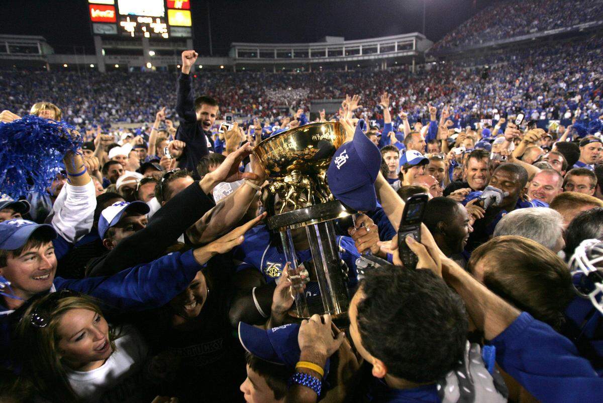 Kentucky fans and players celebrated with the Governor’s Cup trophy after the Wildcats upset No. 9 Louisville 40-34 at Commonwealth Stadium in 2007 in what was the season’s third game.
