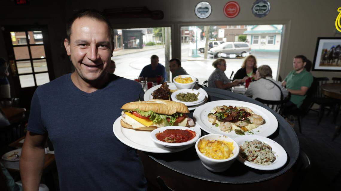 Server, Galin Ivanov showed off a table's order at Chatham's Southern Comfort Food, recently opened at the former Ramsey's High St. and Woodland Ave. location in  Lexington, Ky., on Aug. 8, 2014.  Photo by Pablo Alcala | Staff