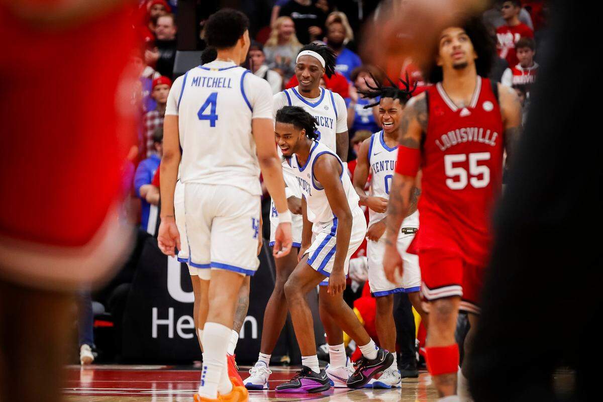 Kentucky guard Antonio Reeves, center, celebrates making a 3-point shot against Louisville during Thursday’s game at the KFC Yum Center.