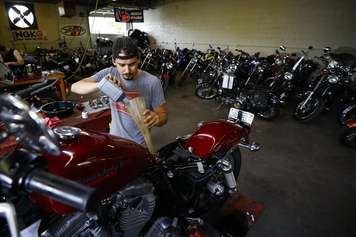 C.J. Payne, of Nicholasville, changed the oil and preformed other maintenance on a motorcycle Thursday at Paradise Cycles in Lexington. A new 6% sales tax on certain services, including vehicle repair, pet grooming and landscaping, will begin on July, 1.