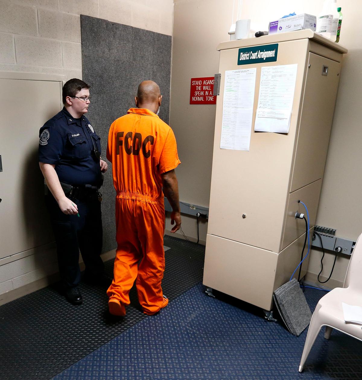 Cpl. Sam Collier led an inmate to the camera and monitor for a district court video arraignment in the Fayette County Detention Center 600 Old Frankfort Pike. The inmates entered a small room where they stood against a carpeted wall and communicated with the judge via video connection.