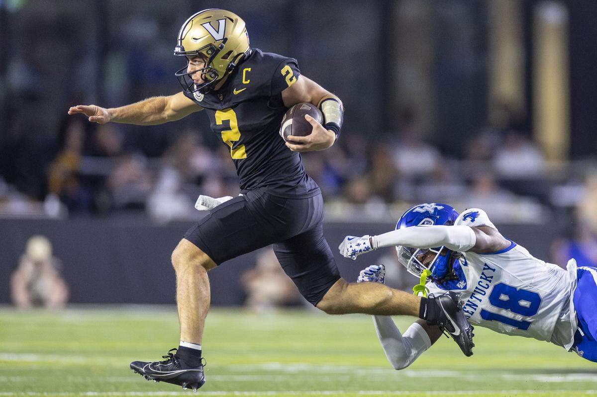 Vanderbilt quarterback Diego Pavia (2) runs past Kentucky defensive back Cam Dooley (18) during Saturday’s game at FirstBank Stadium in Nashville, Tennessee.