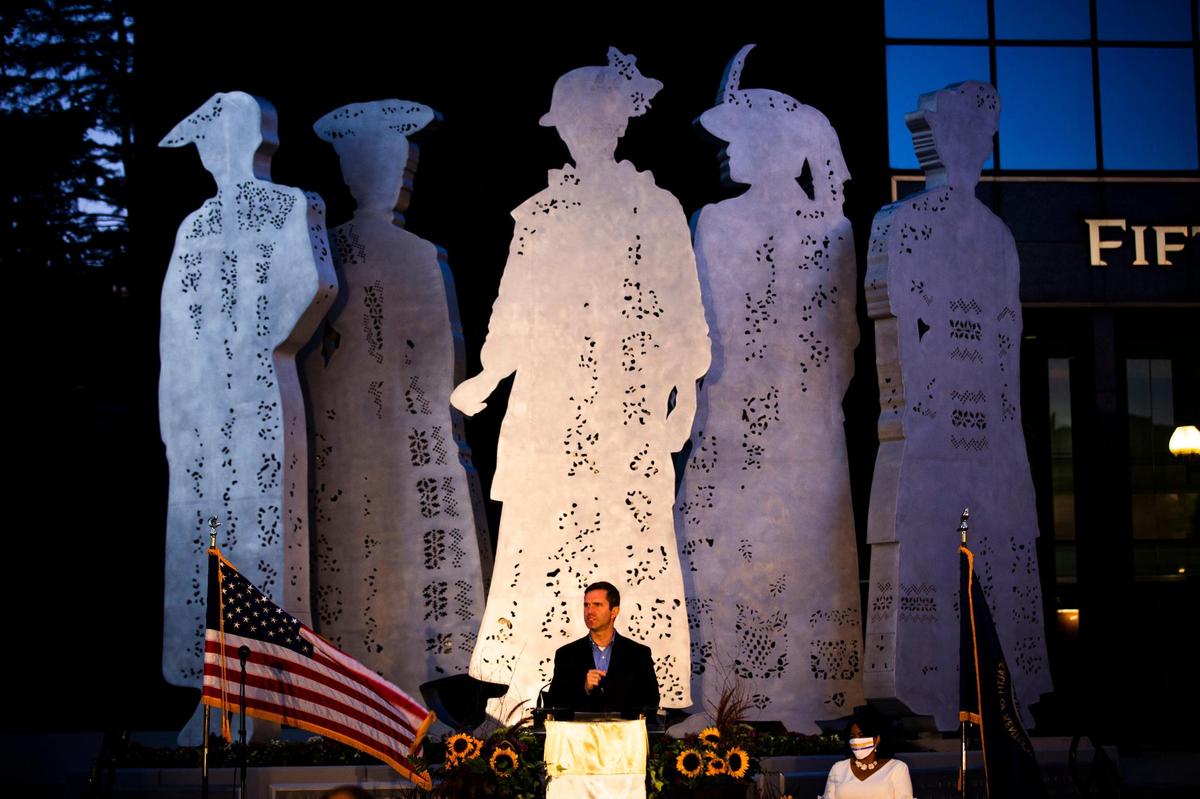 Kentucky Governor Andy Beshear speaks during the dedication of ‘Stand,’ a 20-foot tall sculpture of five female suffragists by Barbara Grygutis, and the celebration of the 100th anniversary of the passage of the 19th Amendment, which gave many women the right to vote, in Lexington, Ky., on Wednesday, August 19, 2020.
