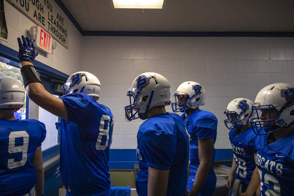 The Breathitt County Bobcats, including Bryce Hoskins, with hand up, a freshman tight end and linebacker, walk out of their locker room before taking the field for their game against South Laurel Friday, Aug. 30, in Jackson. The Bobcats won, 43-8.