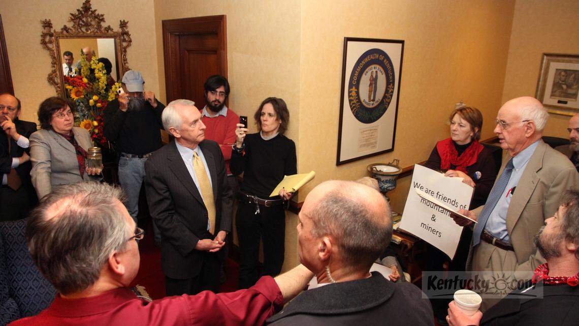 Governor Steve Beshear, center (hands clasped) listened to a statement by Kentucky author Wendell Berry, right, on Friday, Feb. 11, 2011 in the Governor's office outer reception area at the Capitol building in Frankfort, Ky.  Protestors from mostly eastern Kentucky sat (and stood) in Governor Steve Beshear's outer office until he agreed to meet with them concerning their concerns over stream pollution they say arises from surface coal mining.  Gov. Beshear met with them around 1pm Friday.  Several were not satisfied with his responses to their concerns and vowed to remain in the outer office until forced out by arrest.  Photo by David Perry | Staff
