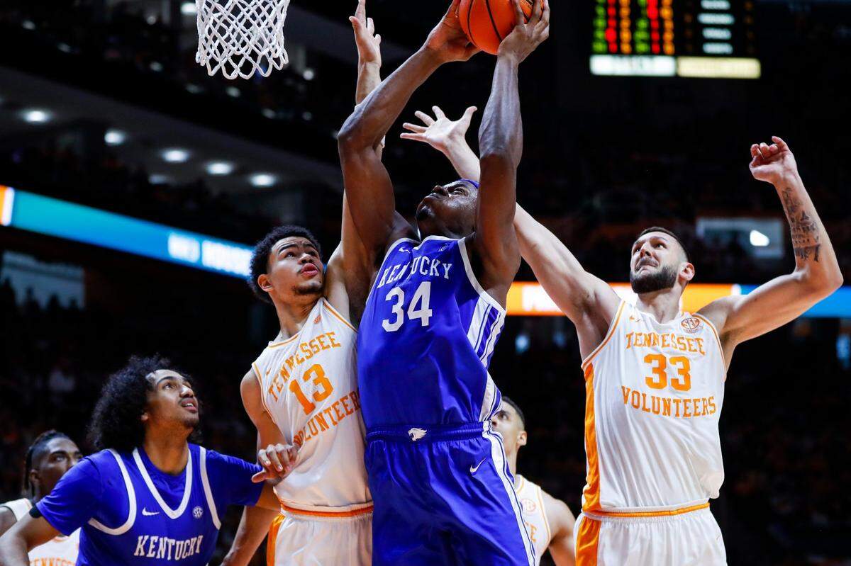 Kentucky’s Oscar Tshiebwe (34) grabs a rebound against Tennessee’s Olivier Nkamhoua (13) and Uros Plavsic (33) during Saturday’s game. Tshiebwe finished with 15 points and 13 rebounds.