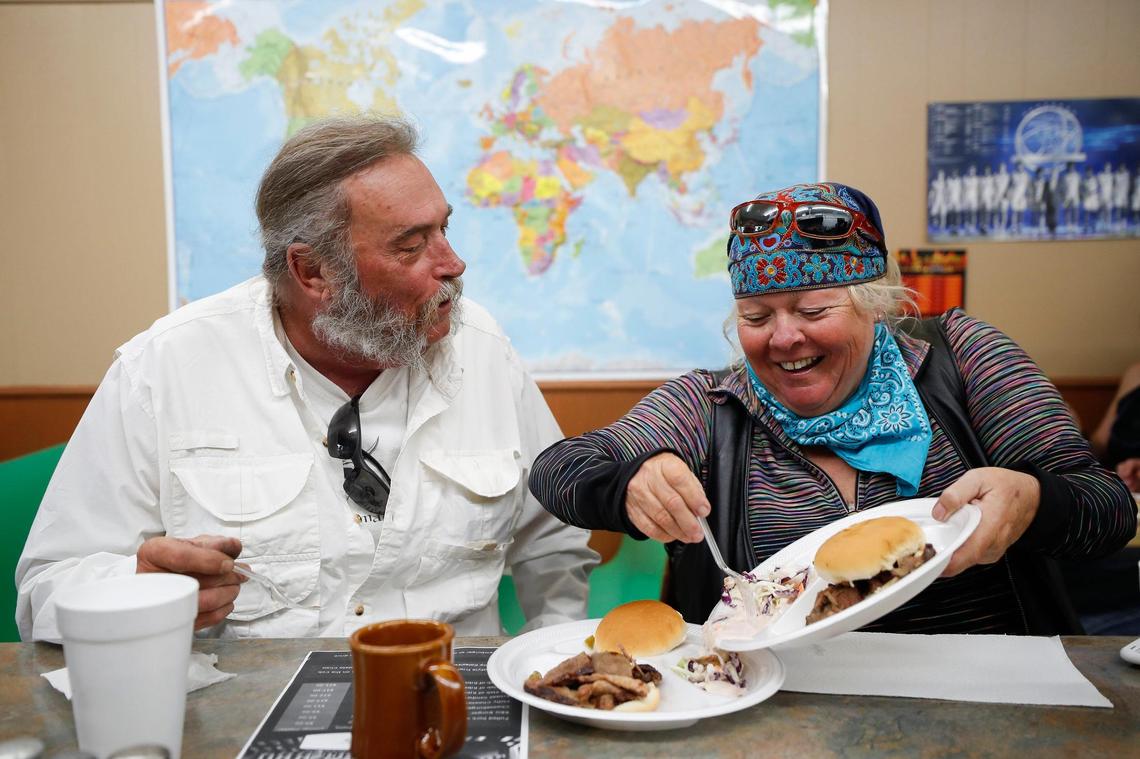 Mac McDougle, of Tampa, Fla., watches as Susan Peacock, also of Tampa, scoops coleslaw onto his plate June 24 at In and Out BBQ. McDougle and Peacock were on a cross country motorcycle trip and stopped at In and Out for lunch.
