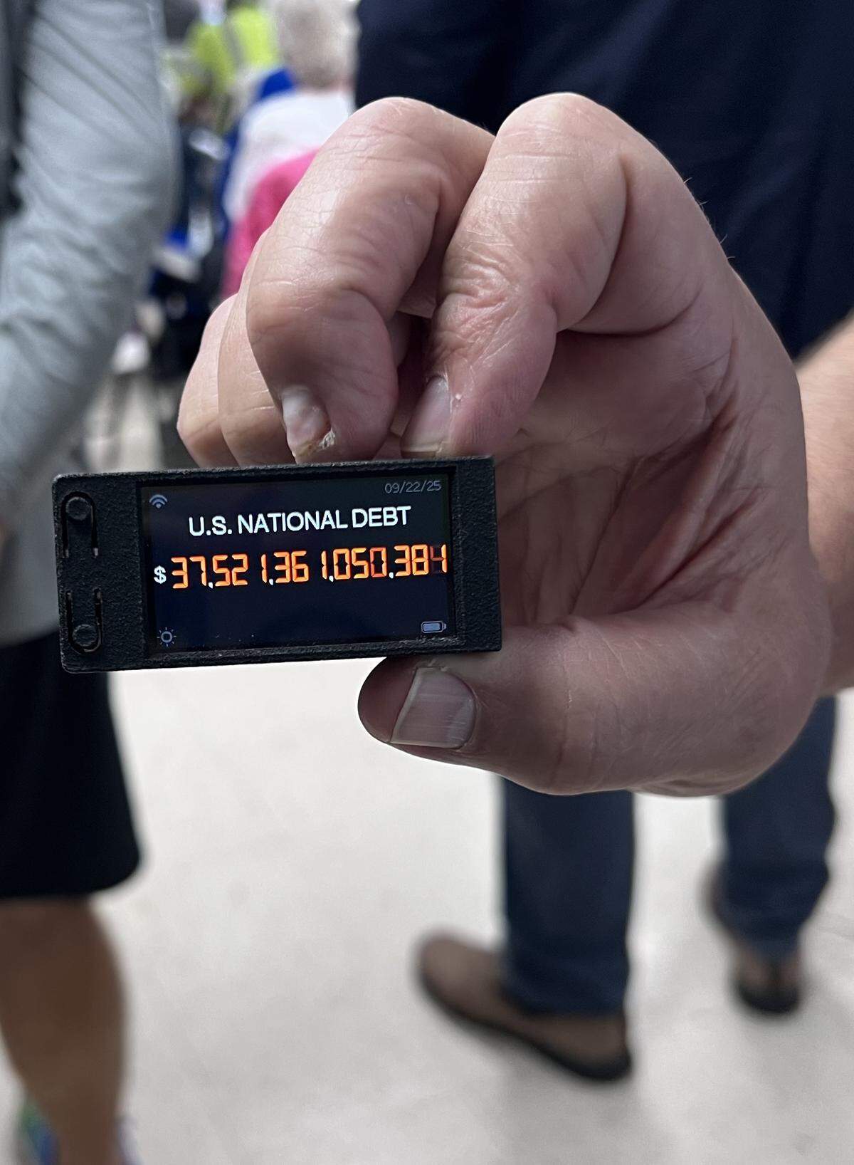 Rep. Thomas Massie passes around his U.S. national debt digital lapel counter for attendees attending an event at the Robertson County Community Center in Mt. Olivet, Ky., on Wednesday, Sept. 24, 2025.