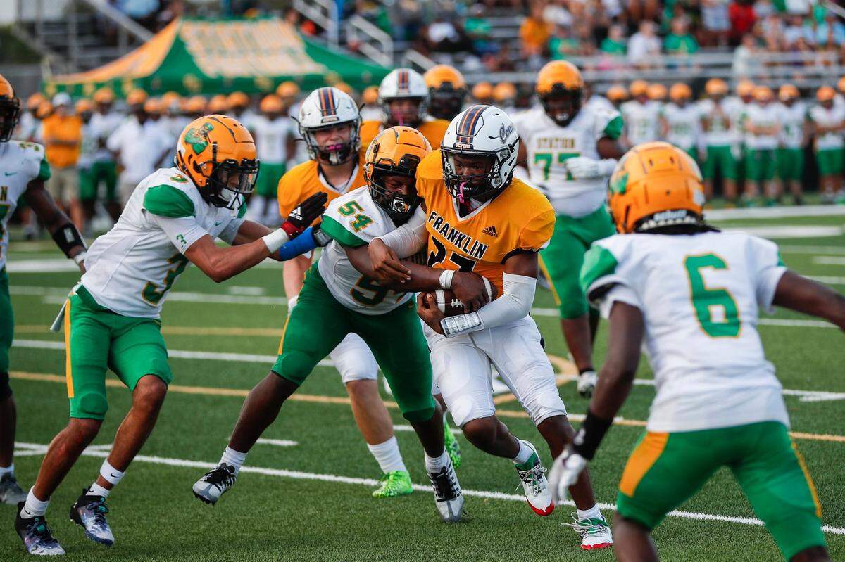 Franklin County’s Jayquan Crawford (27) is tackled by Bryan Station’s Keelan Adams (54) during a game at Boyle County on Aug. 26.