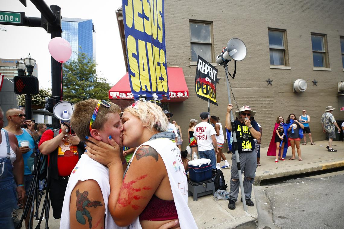 Amber Snow, of Mount Vernon, left, kissed her wife Starla Snow, also of Mount Vernon in front of a group protesters during Lexington Pride Festival 2018 Saturday at courthouse plaza in Lexington.