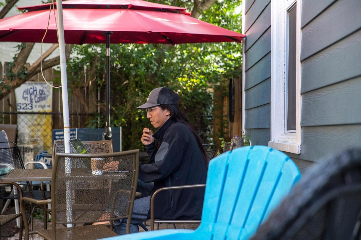 Tan Doan, visiting from Texas, works on his computer in the garden area at High on Art & Coffee at 523 East High St. in Lexington, Ky., on Thursday, Oct. 21, 2021.