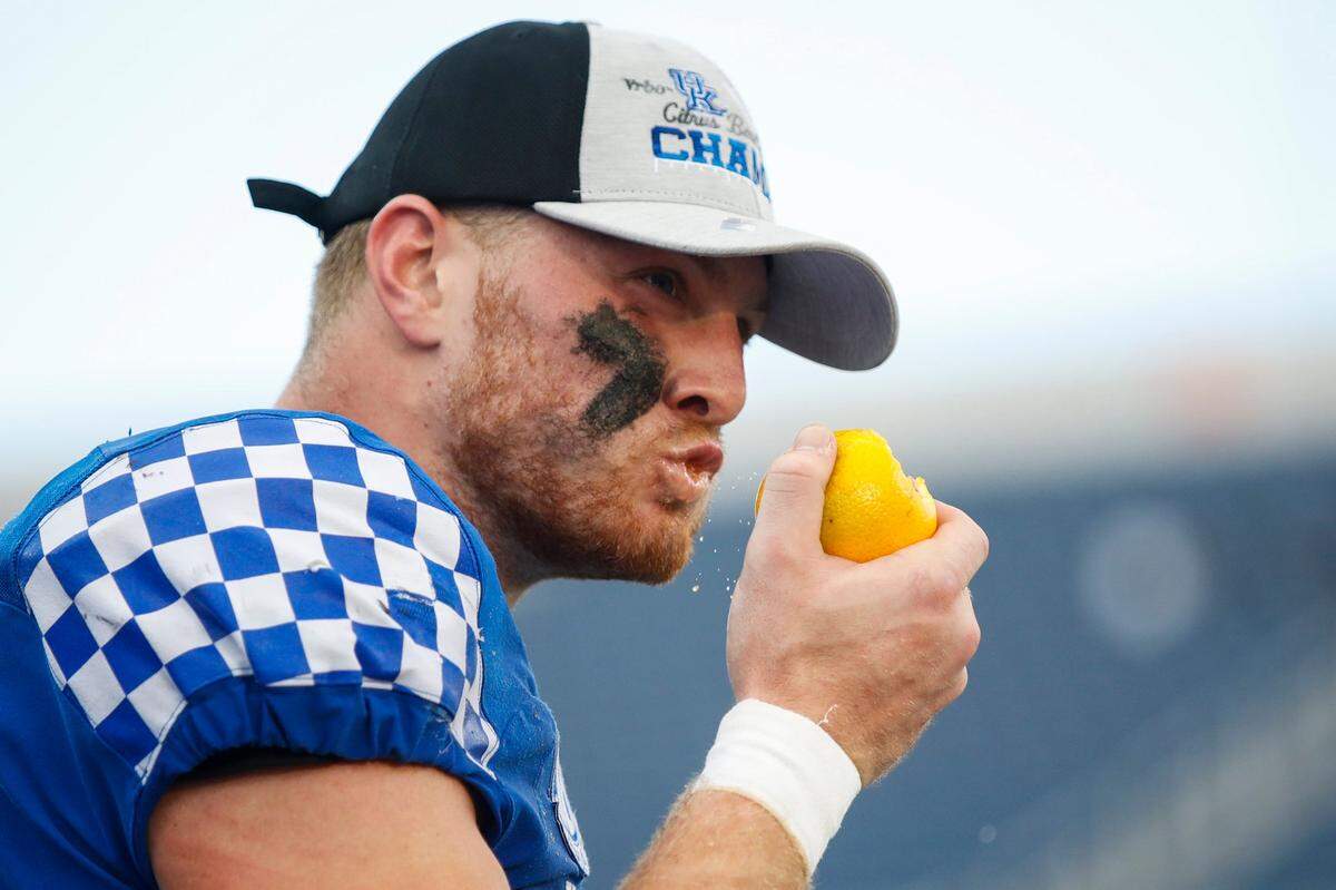 Kentucky quarterback Will Levis (7) takes a bite out of an orange after the Wildcats defeated Iowa 20-17 in the VRBO Citrus Bowl in Orlando on New Year’s Day.
