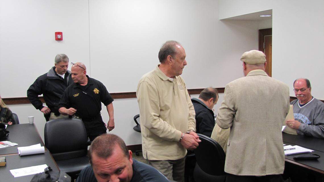 Jackson County Judge-Executive William O. Smith left a fiscal court meeting in handcuffs after Sheriff Denny Peyman, behind Smith, arrested him.