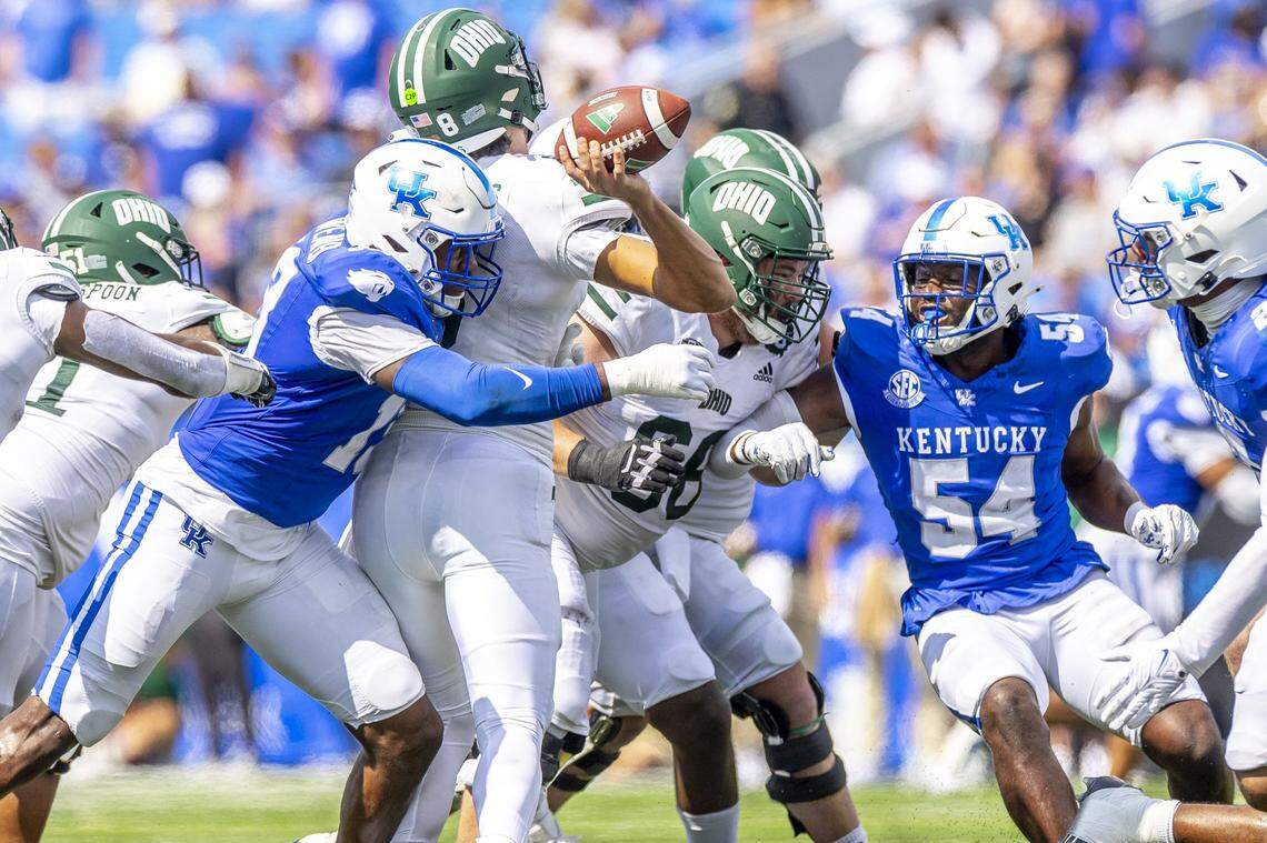 Kentucky linebacker J.J. Weaver (13) hits Ohio quarterback Nick Poulos during Saturday’s game at Kroger Field.