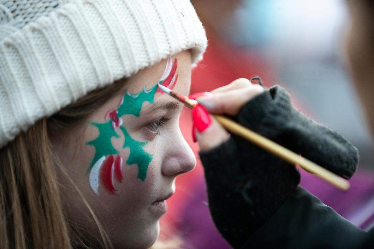 Maggie Hill, 12, had her face painted at the Luminate Lexington holiday event Sunday night in Triangle Park.