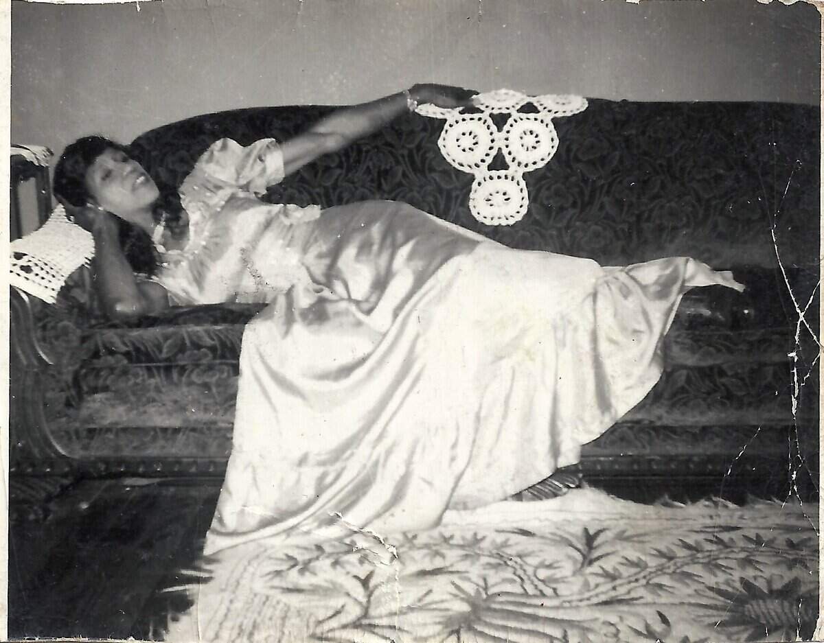 Sweet Evening Breeze, or Sweets, lays on a couch in a white silk dress.