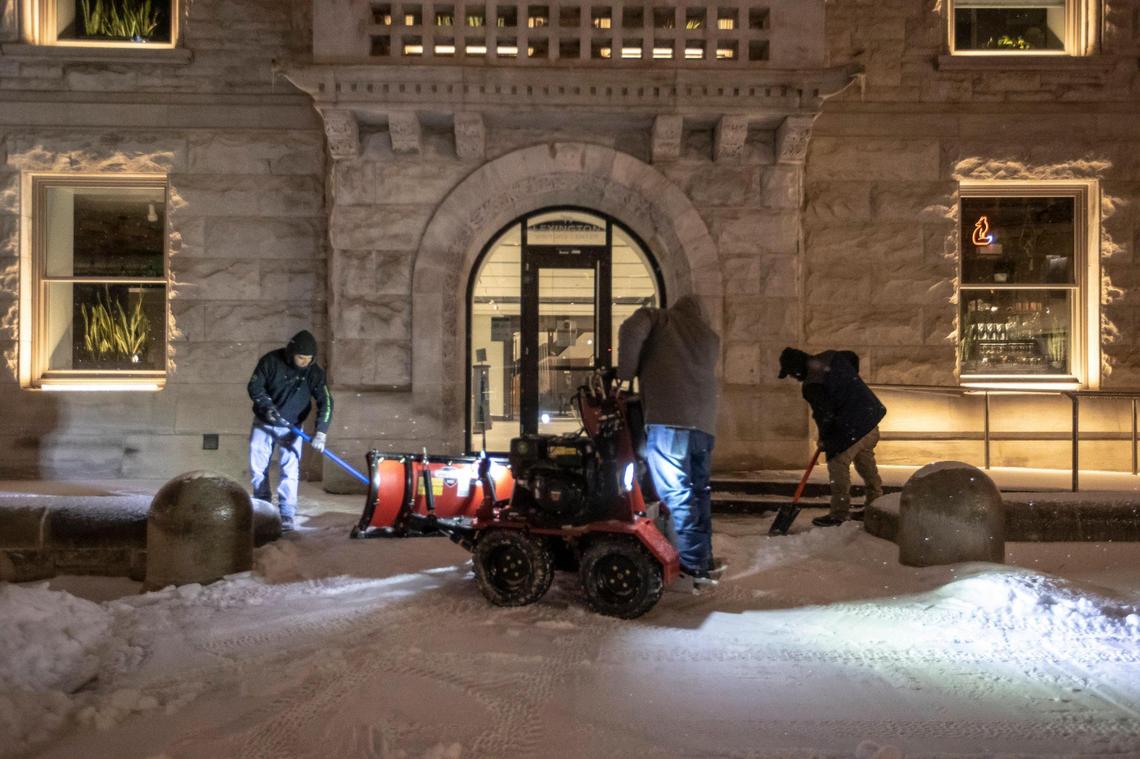 Workers clear snow and ice from an entrance at the Old Fayette County Court House in Lexington, Ky., on Tuesday, Feb. 16, 2021.