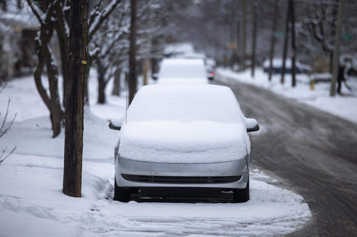 Snow covers a car in Lexington, Ky., Friday, Dec. 12, 2025.