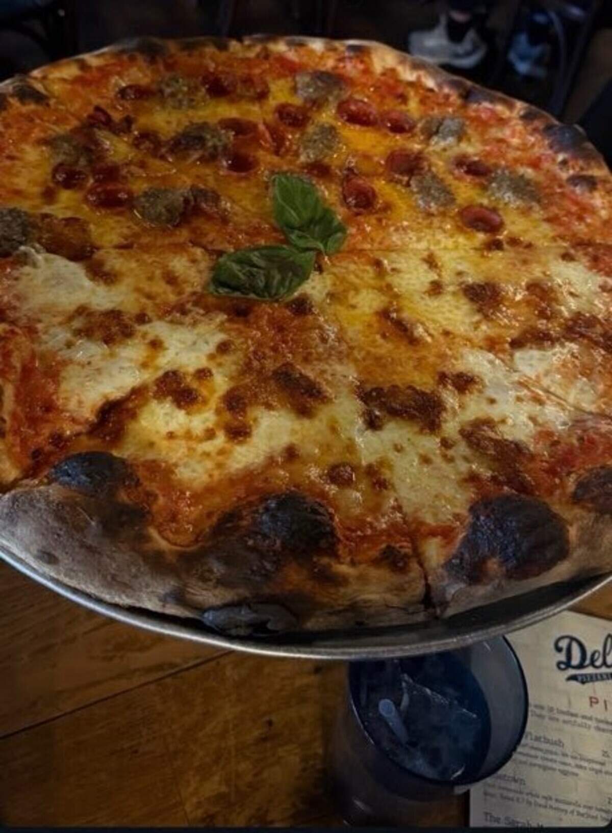 Deluca’s Pizza is known for its large pizzas, cooked at high heat in a pizza oven with a nearly charred crust.