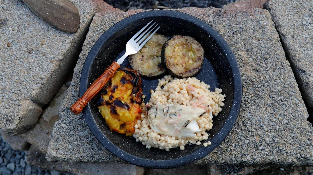Pan seared and buttered tilapia with a white wine cream sauce and shallots served on pearl couscous alongside grilled cucumber and tomato on Tuesday, July 25, 2023 at Bourbon Barrel Cottages in Lawrenceburg, Ky.