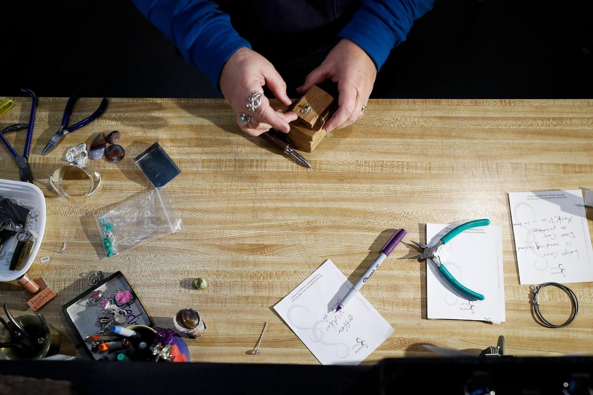 Rachel SavanŽ, of Lexington, Ky., owner and jewelry designer at SavanŽ Silver shows creates ÔcompassionÕ mask pin with an aventurine gemstone at SavanŽ Silver in Lexington, Thursday, Dec. 17, 2020.