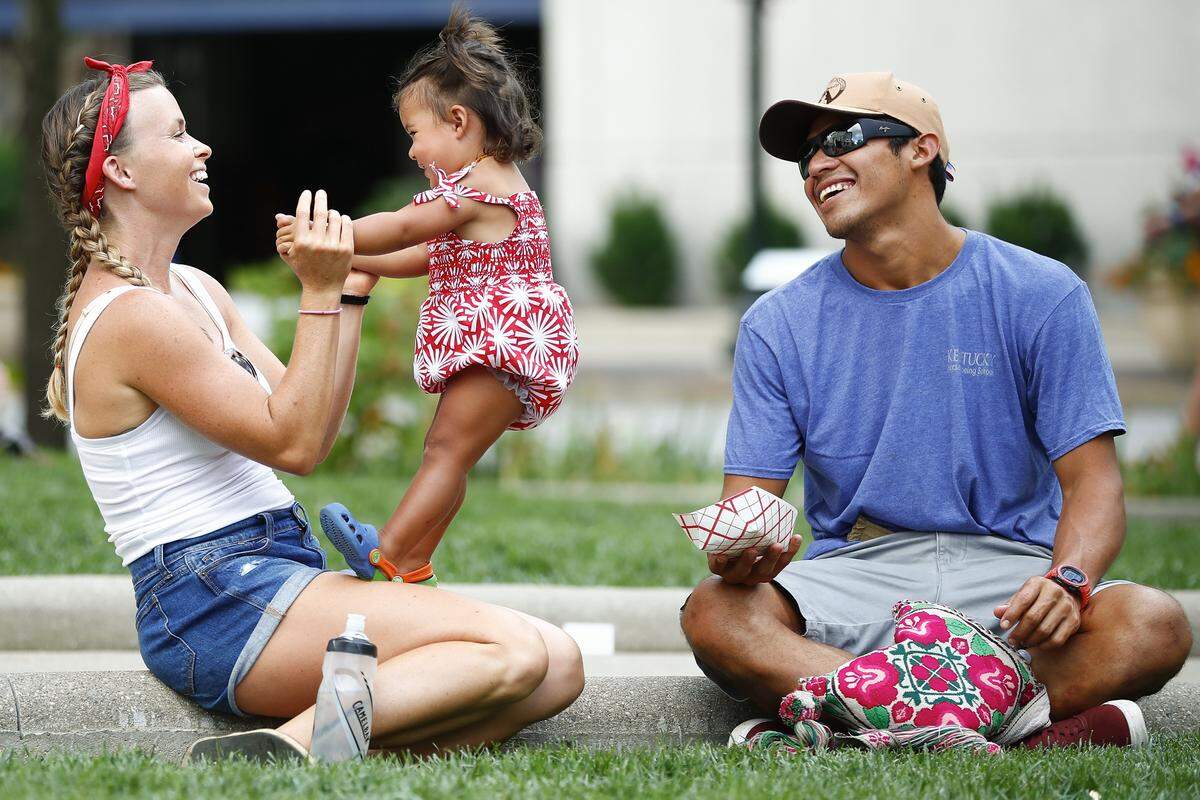 Shelby Taylor, from left, laughs with her daughter Chole Taylor-Jimenez, 1, and husband Javier Jimenez, all of Lexington, Ky., during the city of Lexington’s Fourth of July festival in front of the old Fayette County Courthouse in downtown Lexington Ky., Thursday, July 4, 2019.