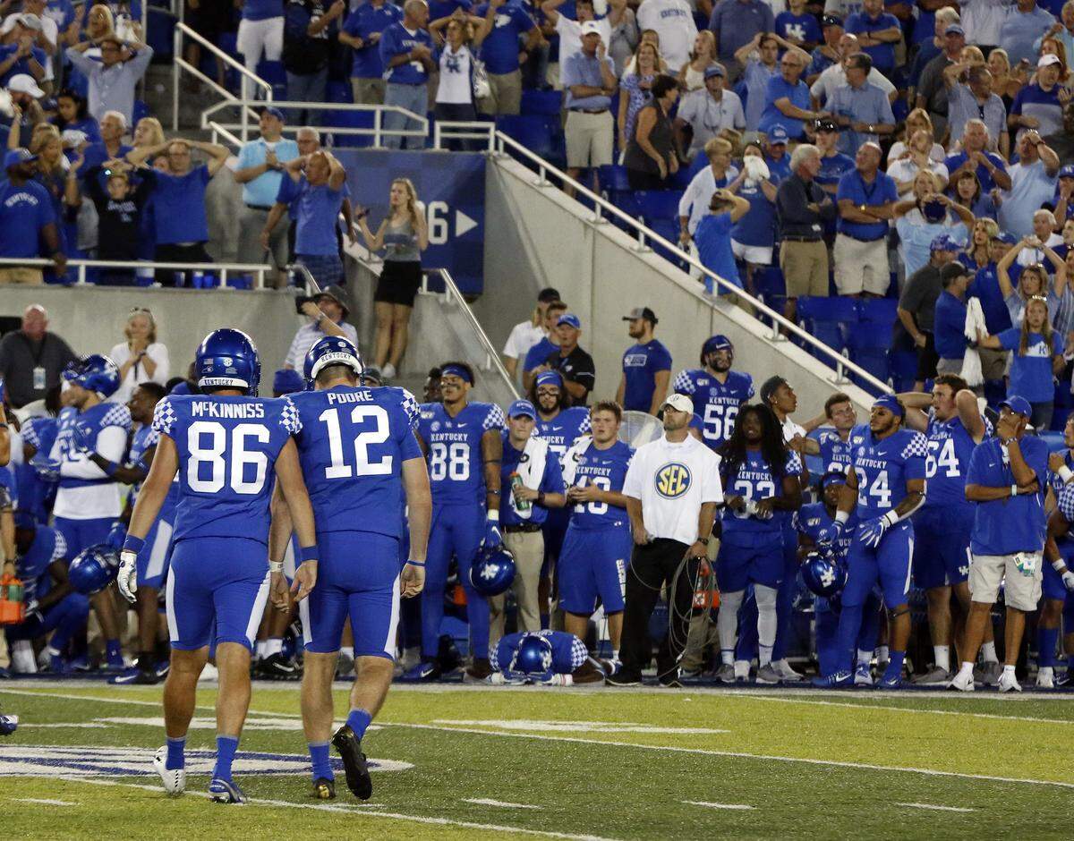 Kentucky place-kicker Chance Poore (12) walked off the field after missing a field goal with 58 seconds left in the game that would have given Kentucky a 24-22 lead over Florida. The Wildcats ended up losing 29-21.