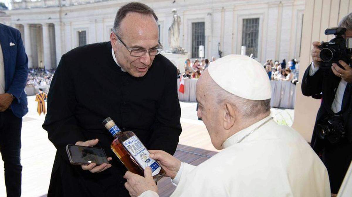 Father Jim Sichko, left, hands a bottle of Wm. Tarr signed by Kentucky football coach Mark Stoops to Pope Francis in Vatican City, Rome.