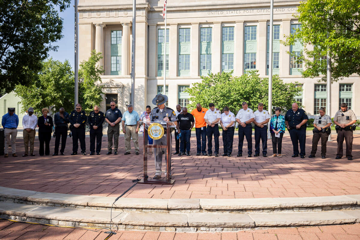 Chaplain Trooper Cory Elliot, center, leads prayer during a community vigil on Tuesday, July 22, 2025, at Robert F. Stephens Courthouse Plaza in Lexington, Ky.